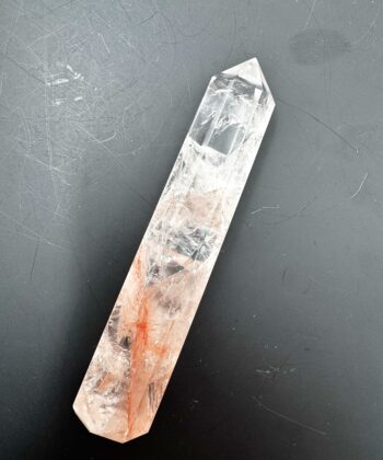 Spids Ildkvarts tårn i klar hvide og rødlige toner på mørk grå baggrund