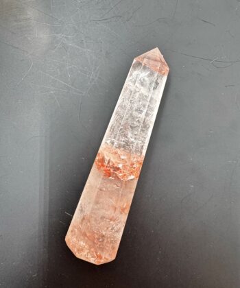 Spids Ildkvarts tårn i klar hvide og rødlige toner på mørk grå baggrund