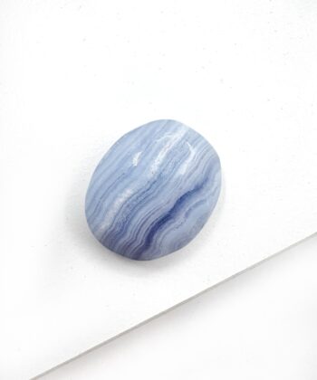 Lyseblå blondeagat oval glat poleret lommesten på hvid baggrund