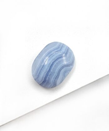 Lyseblå blondeagat oval glat poleret lommesten på hvid baggrund