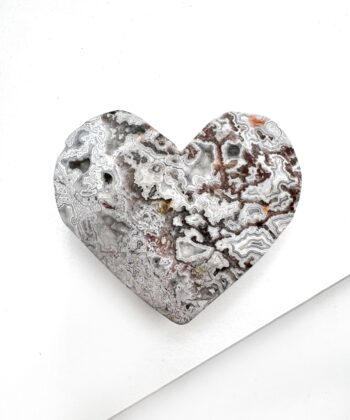 Hjerte formet Agat med landskabsagtigt bølgende mønster i hvid grå og røde toner på hvid baggrund