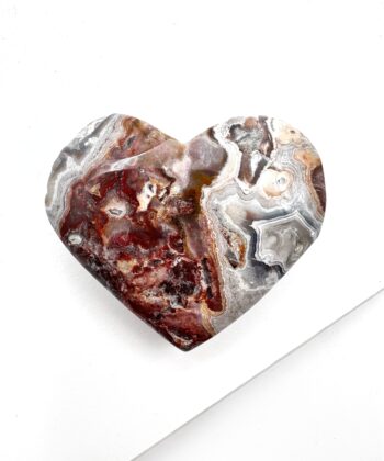 Hjerte formet Agat med landskabsagtigt bølgende mønster i hvid grå og røde toner på hvid baggrund