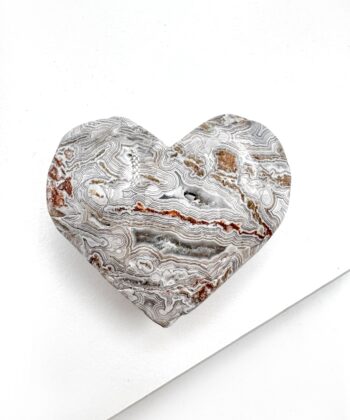 Hjerte formet Agat med landskabsagtigt bølgende mønster i hvid grå og røde toner på hvid baggrund