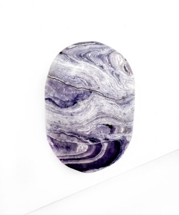 Støvet lilla krystal med hvide bølge blonde mønster gennemgående over glat poleret på hvid baggrund