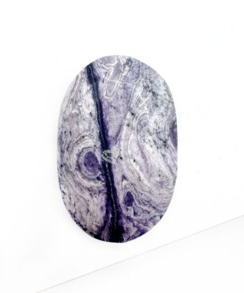 Mild lilla krystal med hvide bølge blonde mønster og en lilla stribe gennemgående over glat poleret på hvid baggrund