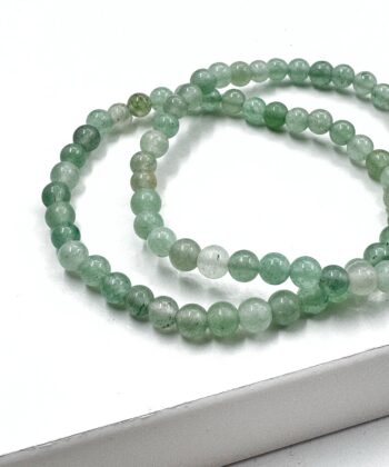 Armbånd med grønne runde poleret perler på hvid baggrund