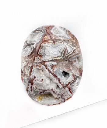 Flad agat med landskabsagtigt bølgende mønster i hvid grå og røde toner på hvid baggrund