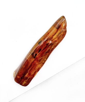 Cognac farvet freeform blødt poleret stykke rav på hvid baggrund