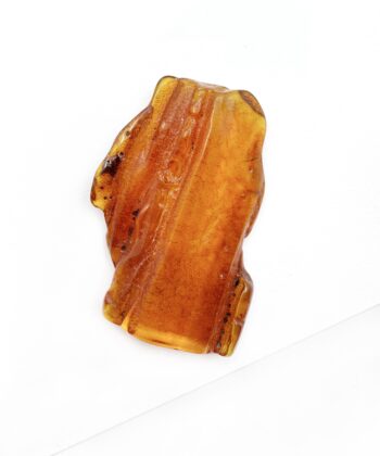 Cognac farvet freeform blødt poleret stykke rav på hvid baggrund
