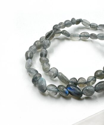 Grå flashy polerede perle stens armbånd på hvid baggrund