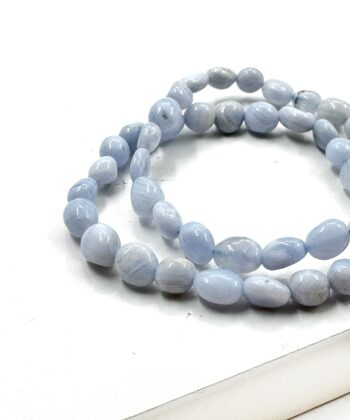 Lyseblå pastel polerede perle stens armbånd på hvid baggrund