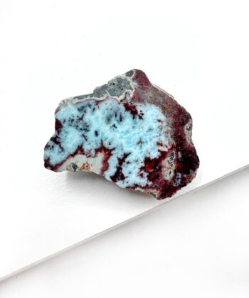 Larimar i blålig hav farver med rødlige noter i med lyse og mørke naturlige mønstre på hvid baggrund