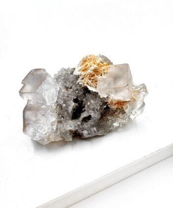 Klar lys rå krystal med orange tekstur på hvid baggrund