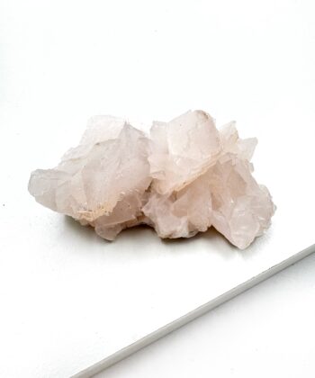 Blid lyserøde og hvide toner rå krystal klynge på hvid baggrund