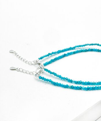 Lyseblå facet armbånd på hvid baggrund.