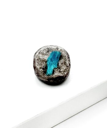 Blå krystal på grå sten med hvid baggrund