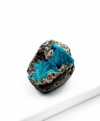 Blå krystal på grå sten med hvid baggrund