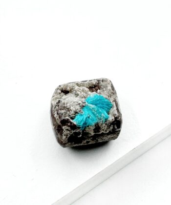 Blå krystal på grå sten med hvid baggrund