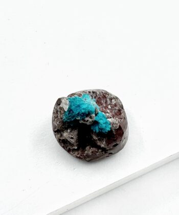 Blå krystal på grå sten med hvid baggrund