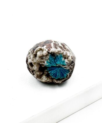 Blå krystal på grå sten med hvid baggrund