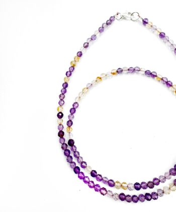 Lilla krystaller i halskæde på hvid baggrund