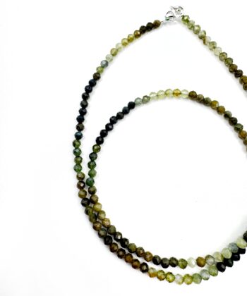 Grøn krystaller i halskæde på hvid baggrund