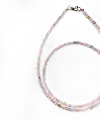 Lyserød krystaller i halskæde på hvid baggrund