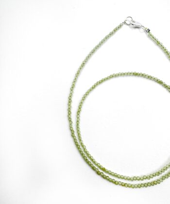 Grøn krystaller i halskæde på hvid baggrund