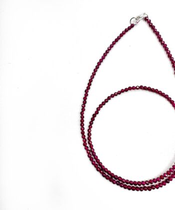Røde krystaller i halskæde på hvid baggrund