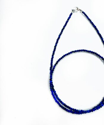 Mørke Blå krystaller i halskæde på hvid baggrund
