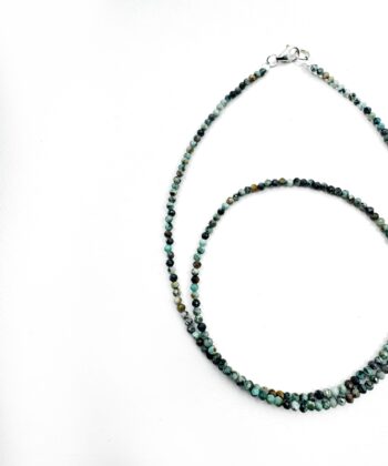 Blå krystaller i halskæde på hvid baggrund