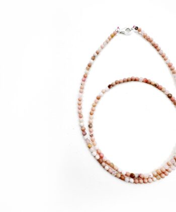 Lyserød krystaller i halskæde på hvid baggrund